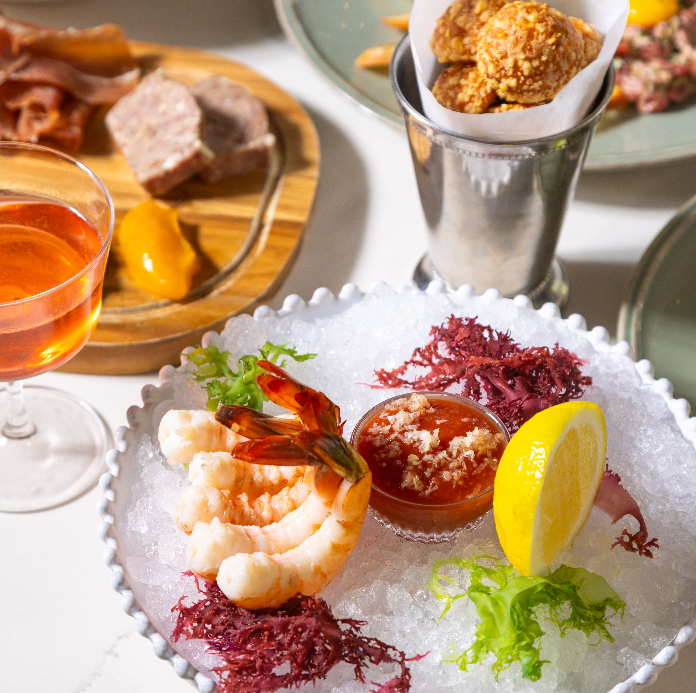 A bright, modern dining scene with plates of fresh food, a marble table, and glasses of beverages, emphasizing healthy and colorful cuisine.